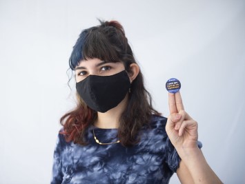 A women shows off her vaccination sticker