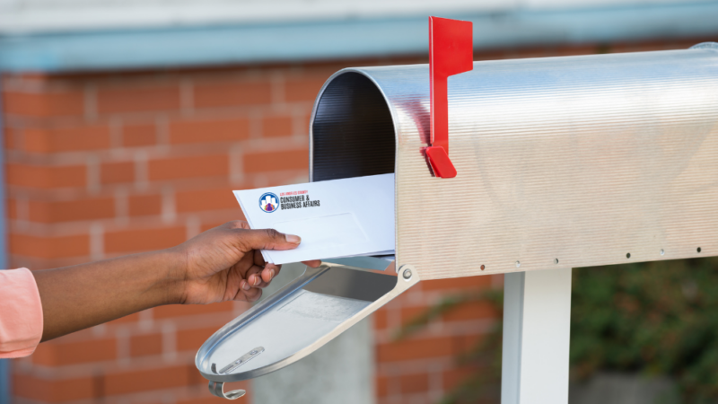 Photo of the arm of a person taking mail out of a mailbox