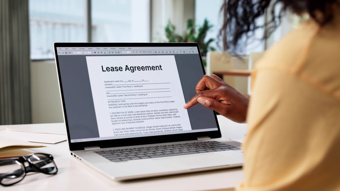 A woman looks through a lease agreement on a computer.