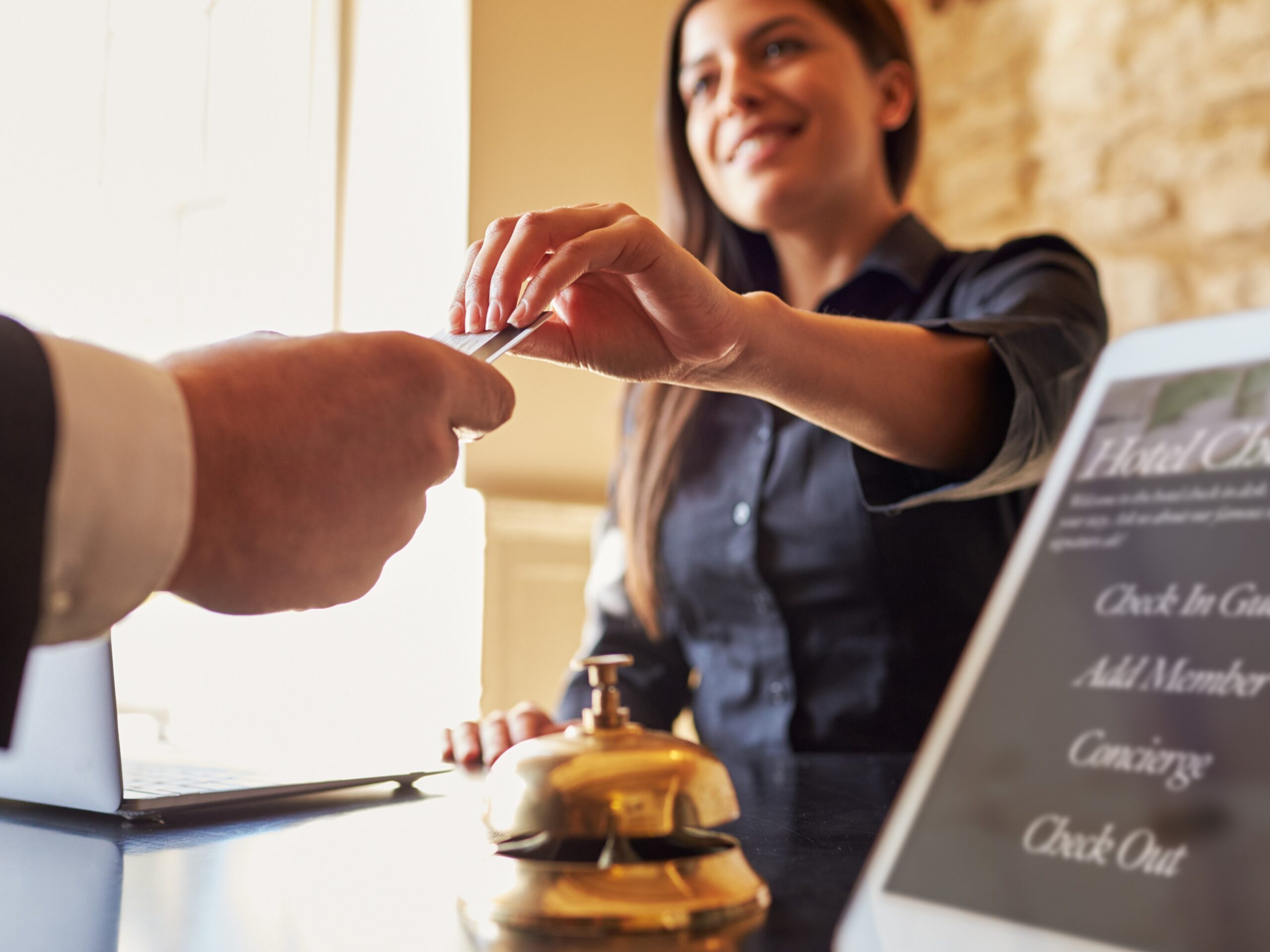 Guest takes room key card from a hotel worker at the check-in desk of hotel, close up